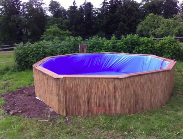Avec seulement neuf palettes en bois, il fabrique sa piscine de jardin pour 50 euros