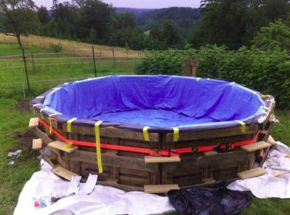 Avec seulement neuf palettes en bois, il fabrique sa piscine de jardin pour 50 euros